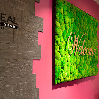 Un tableau de mur végétale nommé "Welcome",  et un logotype l'Oréal professionnel Paris.